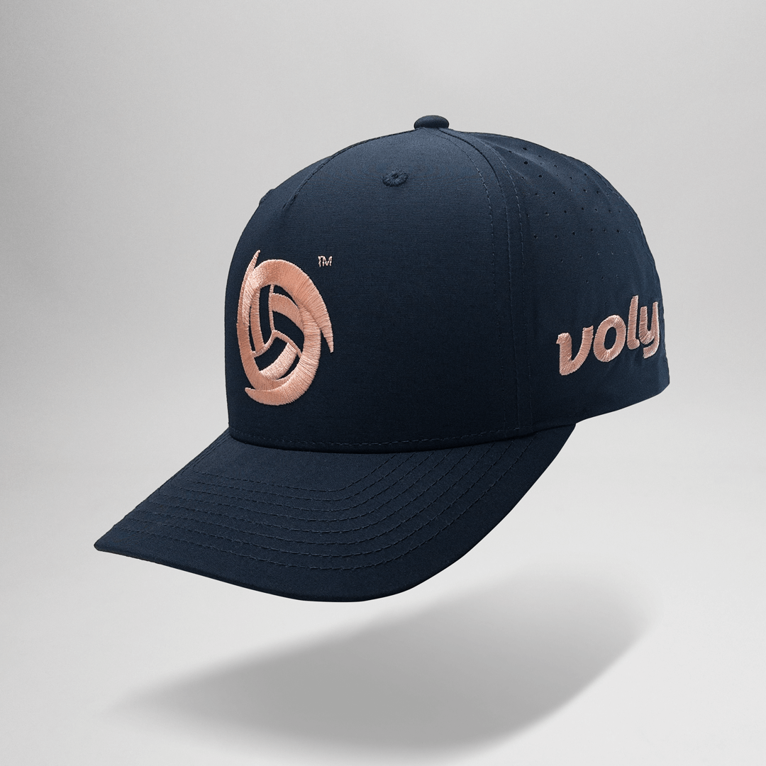 Navy blue cap with peach logo and 'voly' text on a light gray background